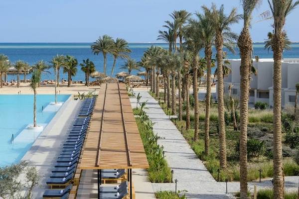 Außenbereich des Serry Beach Resorts mit Pool, Sonnenliegen und Palmen am Meer
