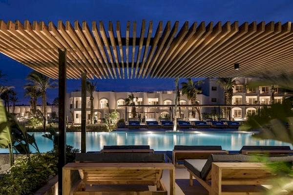 Außenbereich des Serry Beach Resorts bei Nacht mit Holzliegen und Dachterrasse
