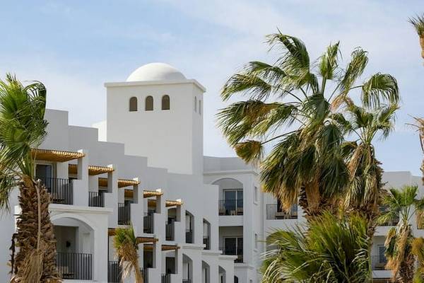 Außenansicht des Serry Beach Resorts mit weißen Gebäuden und Palmen