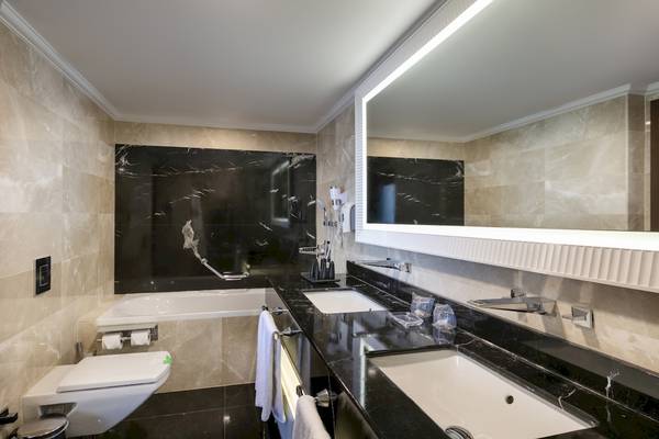 Badezimmer im Dobedan Exclusive Hotel & Spa Belek mit Badewanne, Waschbecken und Spiegel.
