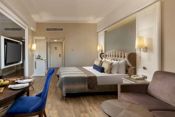 Dobedan Exclusive Hotel & Spa Belek Zimmer mit Doppelbett, Tisch, Fernseher und Lampe