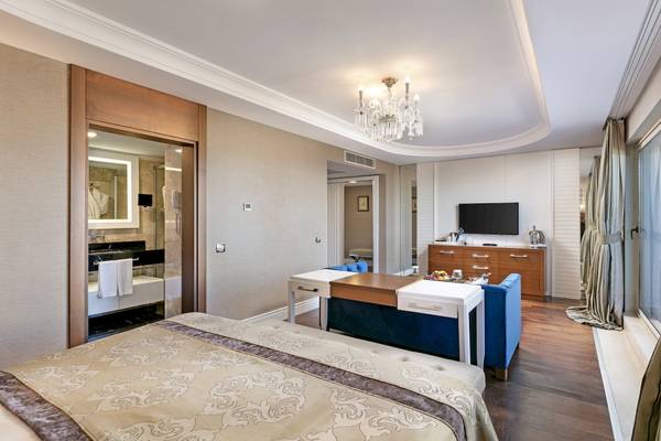 Schlafzimmer des Dobedan Exclusive Hotel & Spa Belek mit Bett, Couch, Fernseher und Badezimmer