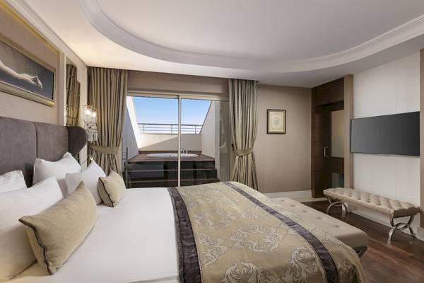 Suite-Schlafzimmer im Dobedan Exclusive Hotel & Spa Belek mit großem Bett, Aussicht und Badewanne.