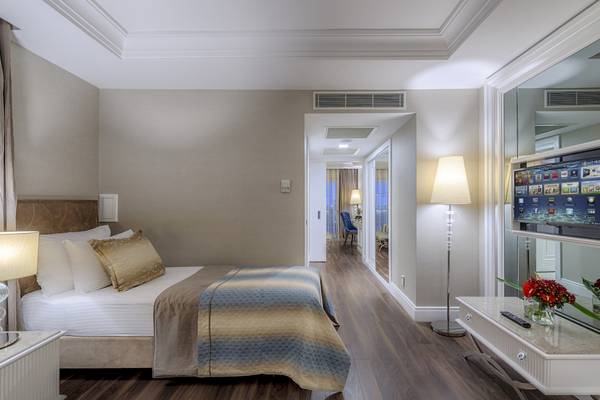 Schlafzimmer im Dobedan Exclusive Hotel & Spa Belek mit Fernseher, Lampen und Blumenvase