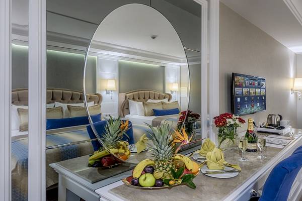 Suite-Zimmer im Dobedan Exclusive Hotel & Spa Belek mit Bett, Schreibtisch, Spiegel und Früchten