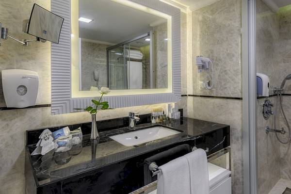 Badezimmer im Dobedan Exclusive Hotel & Spa Belek mit Waschbecken, Spiegel und Dusche
