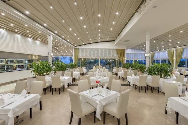 Restaurant des Dobedan Exclusive Hotel & Spa Belek mit gedeckten Tischen und Pflanzen.