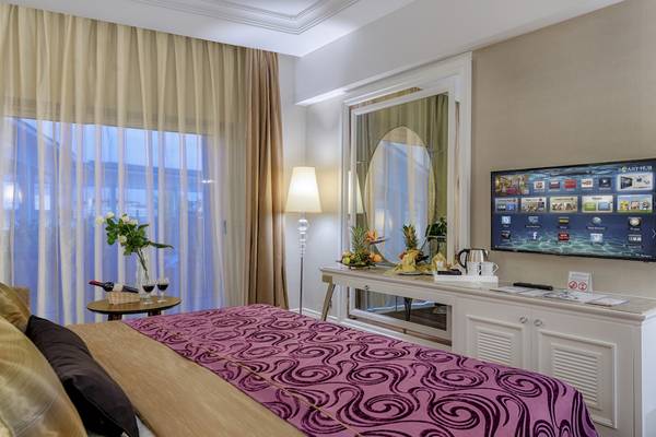 Hotelzimmer im Dobedan Exclusive Hotel & Spa Belek mit Bett, Fernseher, Tisch und Fenster.