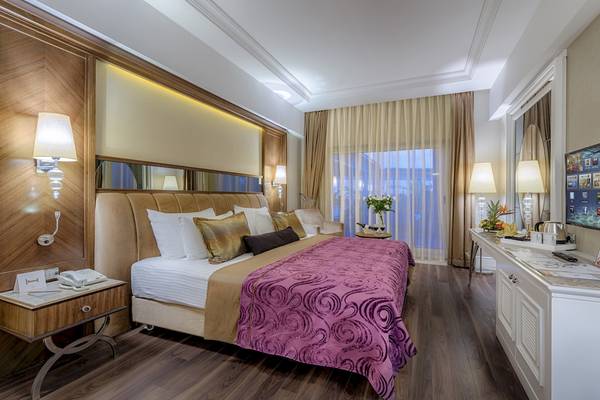 Suite Zimmer im Dobedan Exclusive Hotel & Spa Belek mit Bett, Fernseher und Schreibtisch.