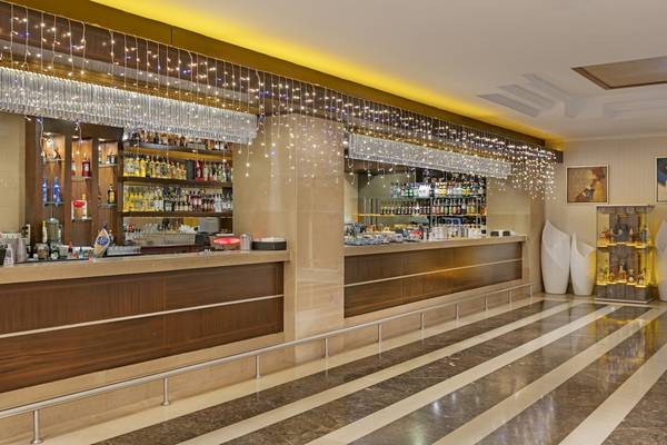 Bar im Dobedan Exclusive Hotel & Spa Belek mit hängenden Lichtern und Getränkeregalen