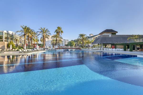 Außenpool des Dobedan Exclusive Hotel & Spa Belek mit Loungeliegen und Palmen