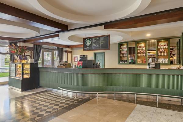 Rezeption im Dobedan Exclusive Hotel & Spa Belek mit grüner Theke und Starbucks-Schild