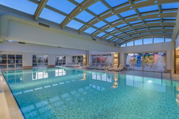 Innenpool im Dobedan Exclusive Hotel & Spa Belek mit vielen Liegestühlen und Glasdach.