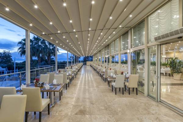 Innenansicht des Restaurants im Dobedan Exclusive Hotel & Spa Belek mit vielen Tischen und Stühlen.