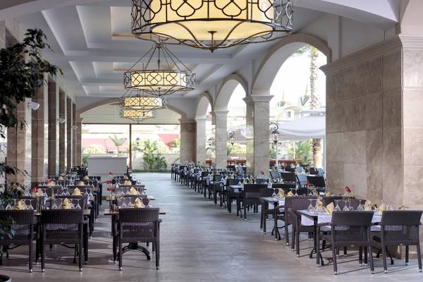 Restaurantbereich im Dobedan Exclusive Hotel & Spa Belek mit gedeckten Tischen und hängenden Kronleuchtern.