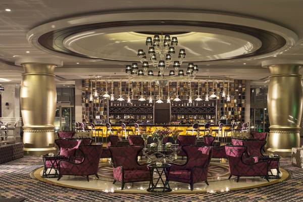 Loungebereich im Dobedan Exclusive Hotel & Spa Belek mit goldenen Säulen und Kronleuchter.