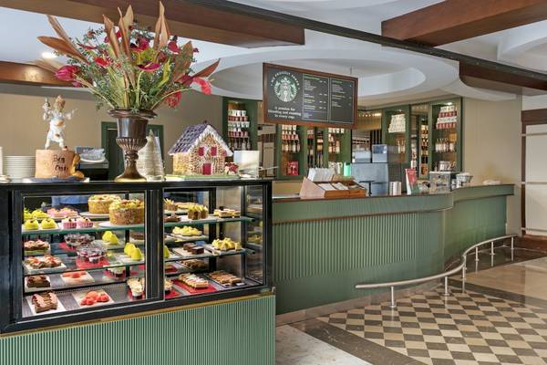 Innenansicht des Cafés im Dobedan Exclusive Hotel & Spa Belek mit Kuchendisplay und grünen Theken.