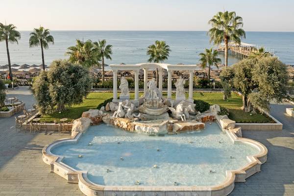 Luftaufnahme des Dobedan Exclusive Hotel & Spa Belek mit einem Brunnen und Meer im Hintergrund.