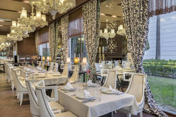 Restaurant im Dobedan Exclusive Hotel & Spa Belek mit weißen Stühlen und Tischen.
