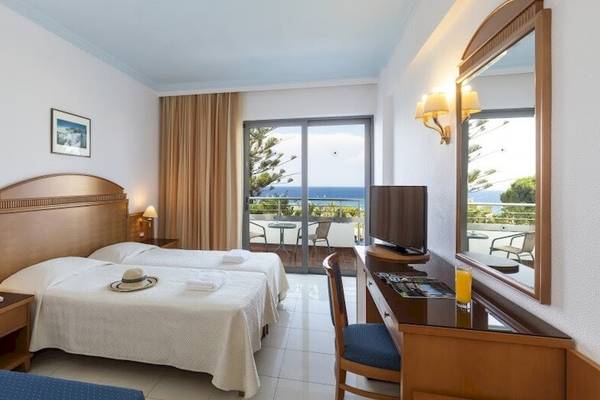 Zweibettzimmer mit Meerblick im Blue Horizon Hotel mit zwei Betten, Schreibtisch, Fernseher, und Balkon.