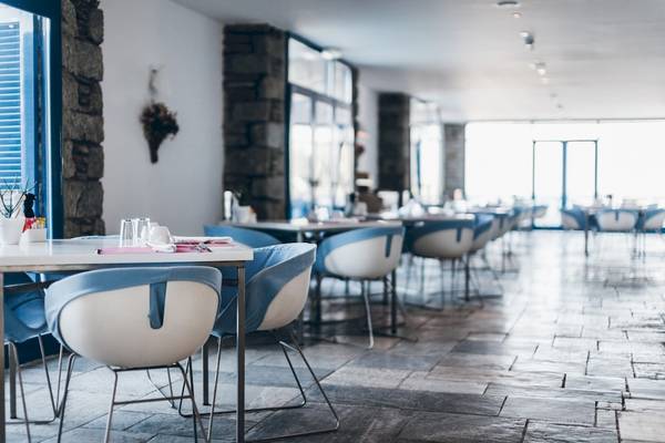 Restaurant im Mykonos Theoxenia Boutique Hotel mit blauen Stühlen und Tischen.