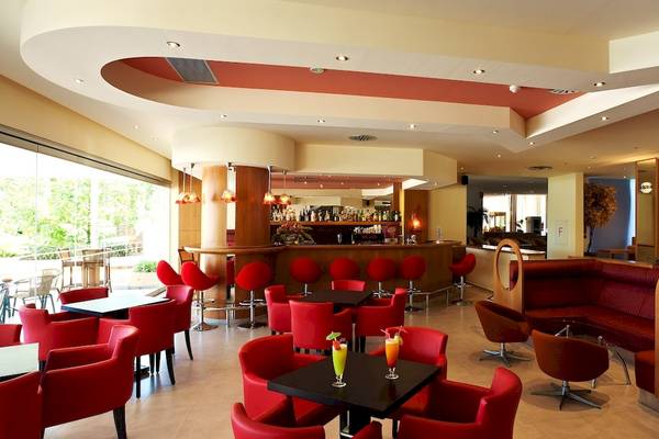 Innenansicht der Bar im Blue Horizon Hotel mit roten Stühlen und Tischen.