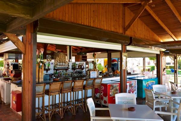 Innenansicht der Bar im Blue Horizon Hotel mit Barhockern, Tischen und verschiedenen Getränken.