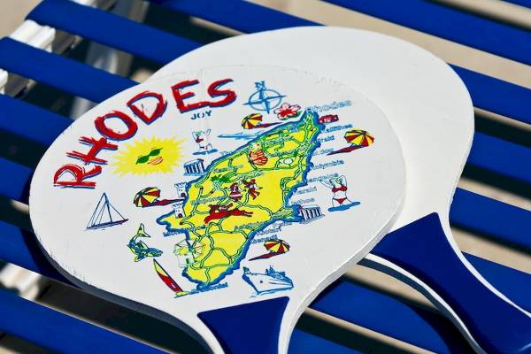 Zwei Paddle mit einer Karte von Rhodos, auf einem blauen Stuhl platziert.