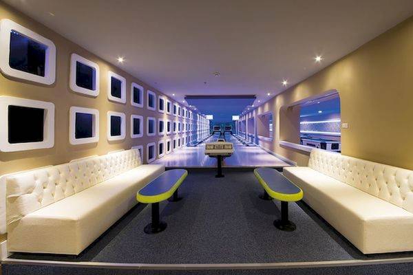 Bowlinghalle im Limak Atlantis Deluxe Hotel mit weißen Sofas und bunten Bänken.