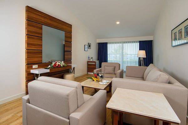 Foto eines stilvollen Wohnzimmers im Limak Atlantis Deluxe Hotel & Resort mit Sofas, Tischen und Fernseher.