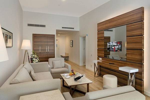 Hotelsuite-Wohnbereich mit Sofa, Tisch und Fernseher im Limak Atlantis Deluxe Hotel & Resort.