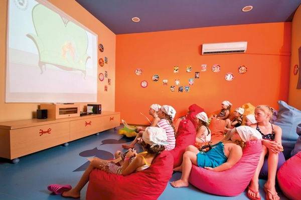Kinder sitzen in roten und pinken Sitzsäcken im Kinoraum des Limak Atlantis Deluxe Hotel & Resort