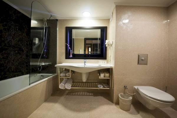 Badezimmer im Limak Atlantis Deluxe Hotel & Resort mit Badewanne, Dusche, Spiegel, Toilette und Waschbecken.