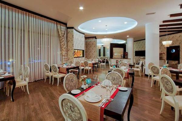 Innenansicht des Restaurants im Limak Atlantis Deluxe Hotel & Resort mit geräumigen Tischen und Stühlen.