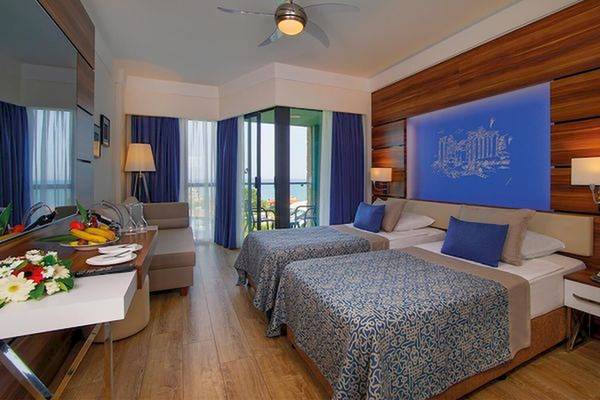 Zwei Betten mit blauen Kissen in einem Hotelzimmer des Limak Atlantis Deluxe Hotel & Resort