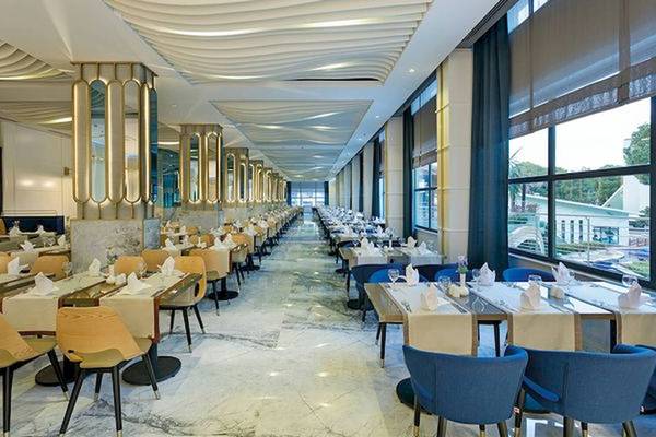 Restaurantbereich im Limak Atlantis Deluxe Hotel & Resort mit gedeckten Tischen und modernen Möbeln.