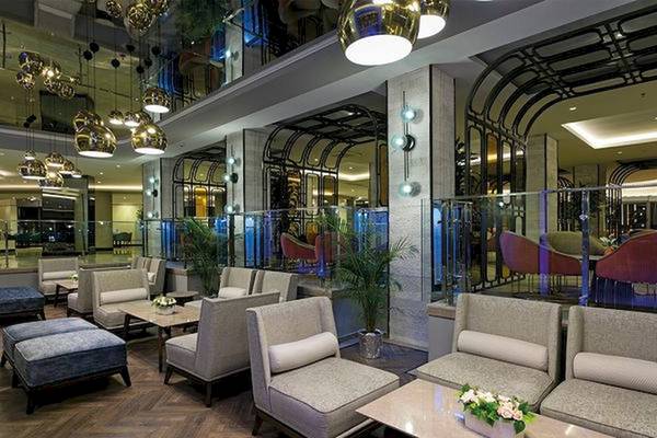 Innenansicht der Lobby des Limak Atlantis Deluxe Hotel & Resort mit Möbeln und Pflanzen.