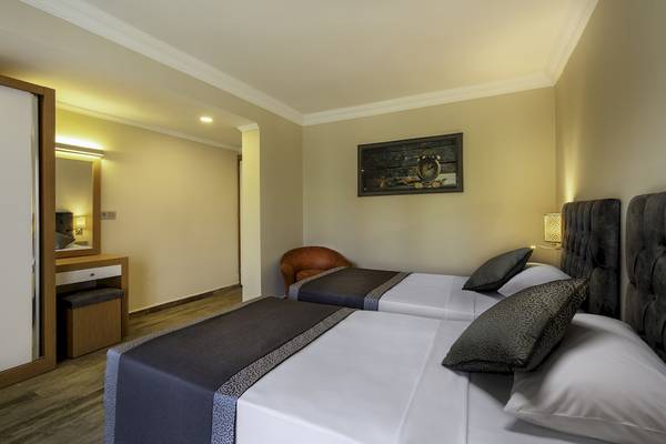 Innenansicht eines Hotelzimmers im VONRESORT Golden Beach mit zwei Betten, Dekor und Möbeln.