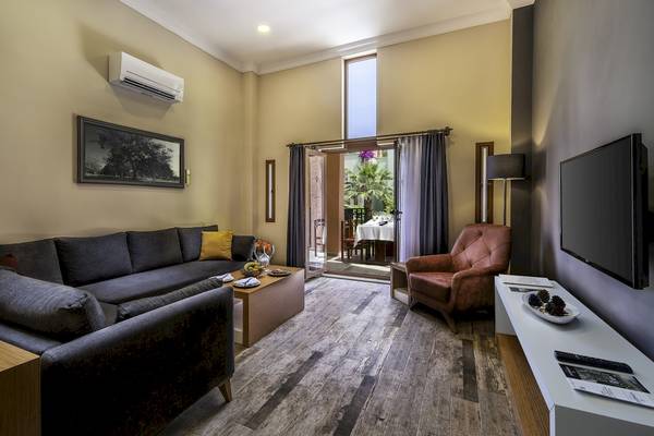 Vonresort Golden Beach Wohnzimmer mit Sofa, Fernseher und Tisch mit Früchten.