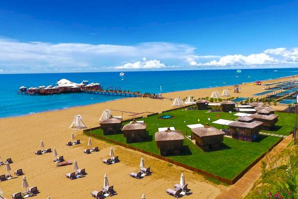Luftaufnahme des Vonresort Golden Beach mit Strand, Wassersport und Sonnenschirmen