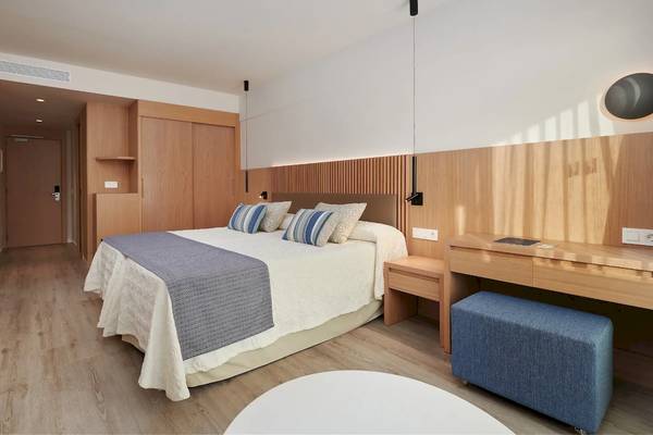 Innenansicht eines Zimmers im Hipotels Mediterraneo Hotel mit Doppelbett, Nachttischen und Fernseher an der Wand.