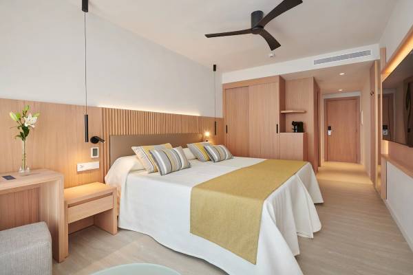 Ein elegantes Hotelzimmer im Hipotels Mediterraneo mit einem Doppelbett, Holzmöbeln und einer modernen Einrichtung.