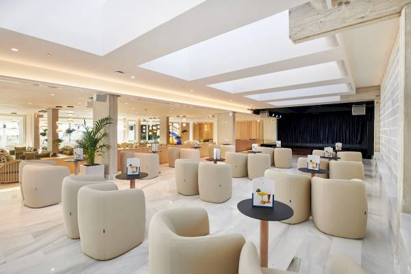 Lounge-Bereich im Hipotels Mediterraneo mit weißen Möbeln und Pflanzen.