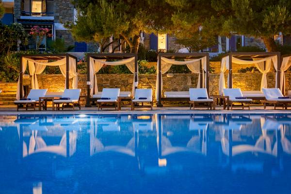 Pool-Loungebereich im Mykonos Theoxenia Boutique Hotel mit beleuchteten Zelten.