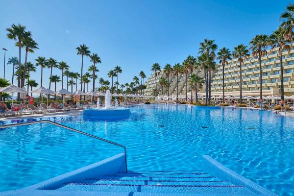 Außenbereich des Hipotels Mediterraneo Hotels mit Swimmingpool und Sonnenliegen.