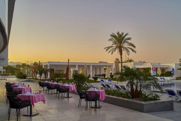 Außenbereich des Maritim Jolie Ville Resort & Casino Sharm El Sheikh mit Tischen und Stühlen.