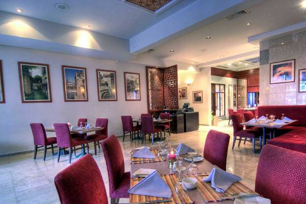 Innenansicht des Restaurants im Maritim Jolie Ville Resort & Casino Sharm El Sheikh mit gedeckten Tischen und Stühlen.