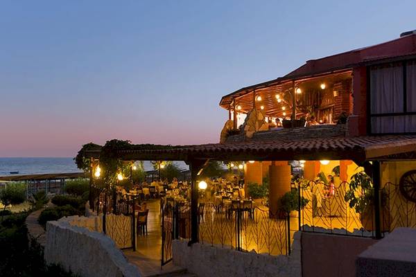 Abendansicht des Sentido Kamelya Selin Hotels mit Blick auf das Meer und beleuchtete Terrasse.