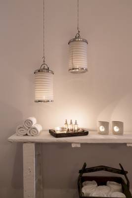 Badezimmer im Mykonos Theoxenia Boutique Hotel mit weißen Handtüchern und Kerzen