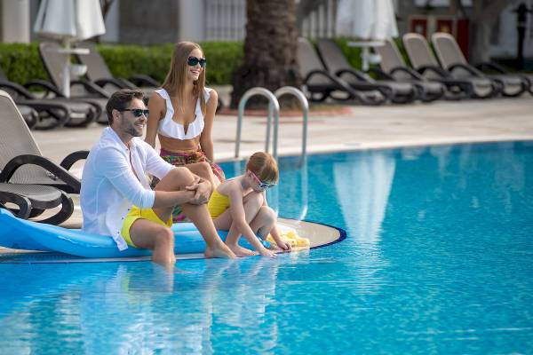 Eine Familie, bestehend aus zwei Erwachsenen und einem Kind, genießt den Pool im Sentido Kamelya Selin.
